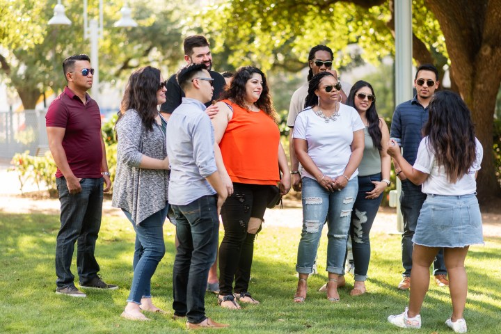 a group of people that are standing in the grass