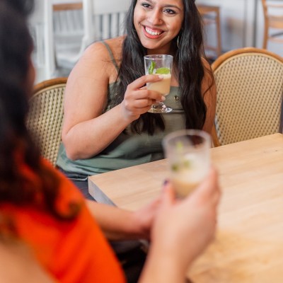 a woman sitting at a table with wine glasses
