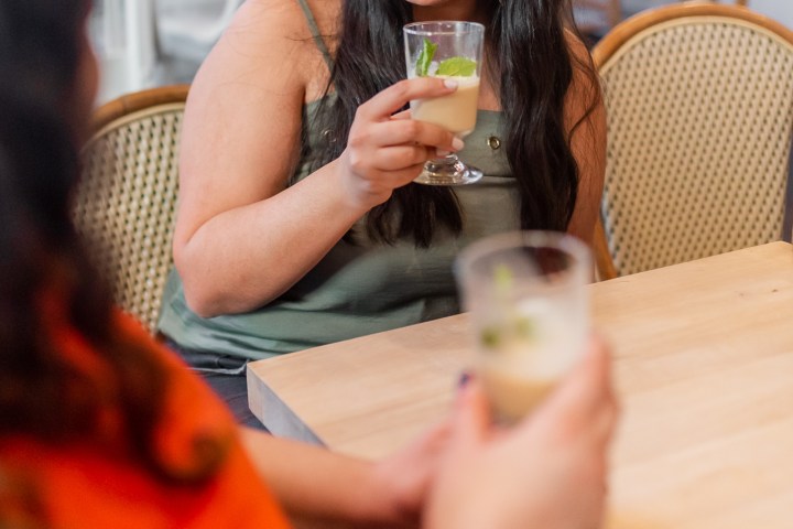 a woman sitting at a table with wine glasses