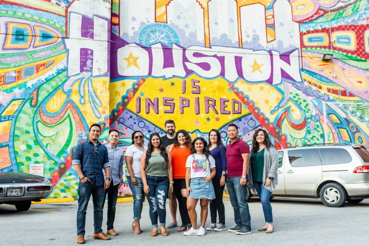a group of people standing next to a car